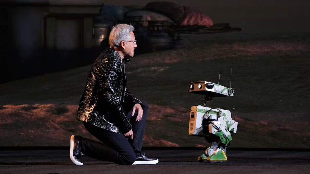 Jensen Huang, fundador y consejero delegado de Nvidia, se arrodilla frente a un robot durante su presentación en la CES de Las Vegas, en un gesto que simboliza el protagonismo de la inteligencia artificial.
