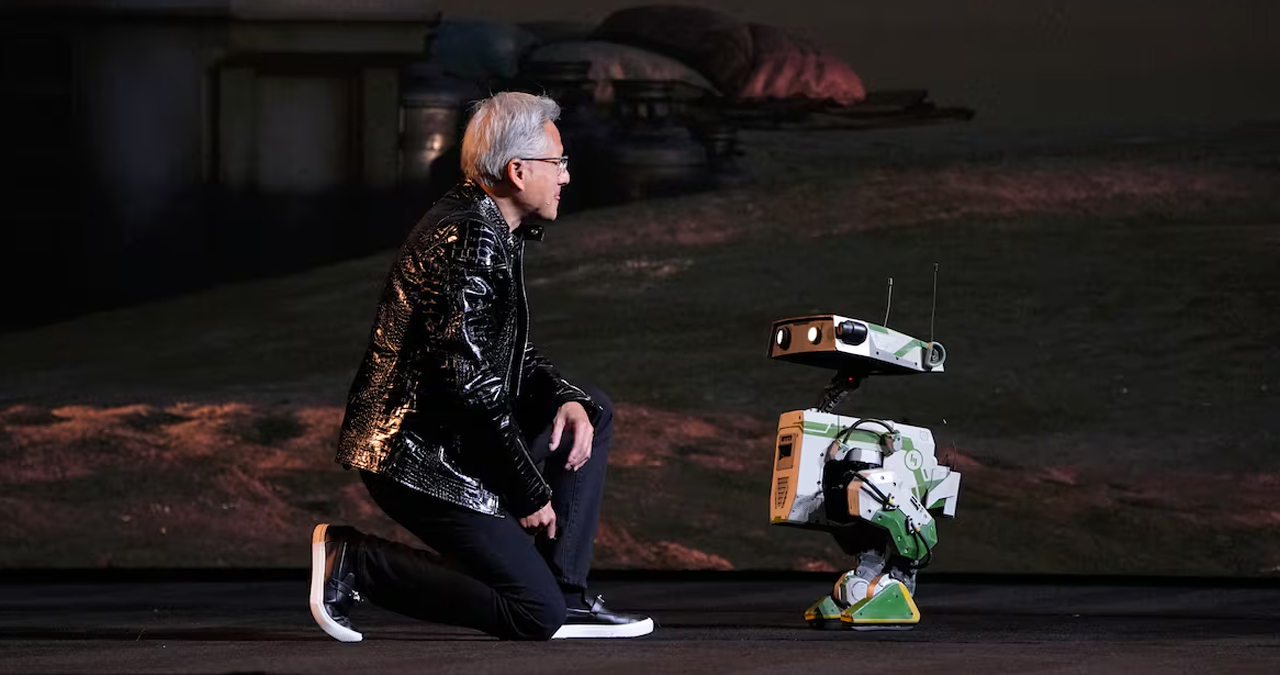 Jensen Huang, fundador y consejero delegado de Nvidia, se arrodilla frente a un robot durante su presentación en la CES de Las Vegas, en un gesto que simboliza el protagonismo de la inteligencia artificial.